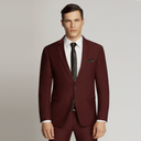 A man modeling a slim-fit burgundy suit with a white dress shirt, black tie, and matching pocket square against a light gray studio background.