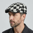 Dupplin Argyle Flat Cap Argyle black | Place this hat on the head of a male. The image should be taken in a studio setting on a light grey backround.