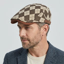 Dupplin Argyle Flat Cap Argyle coffee | Place this hat on the head of a male. The image should be taken in a studio setting on a light grey backround.