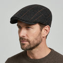Graph Check Flat Cap Black/red | Place this hat on the head of a male. The image should be taken in a studio setting on a light grey backround.