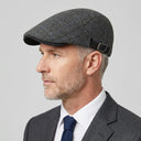 Graph Check Flat Cap Charcoal/blue | Place this hat on the head of a male. The image should be taken in a studio setting on a light grey backround.