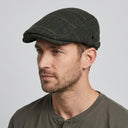 Graph Check Flat Cap Olive/red | Place this hat on the head of a male. The image should be taken in a studio setting on a light grey backround.