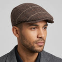 Graph Check Flat Cap Reddish Brown/orange | Place this hat on the head of a male. The image should be taken in a studio setting on a light grey backround.