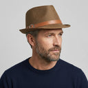 Men's Summer Trilby STRAW BROWN WITH LEATHER | Place this hat on the head of a male. The image should be taken in a studio setting on a light grey backround.