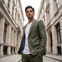 Oliver Jacket Moss | Use the previously generated image as the primary visual reference for the model, clothing, environment, city street, architecture, lighting, styling, color pal