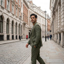 Oliver Jacket Moss | Use the previously generated image as the primary visual reference for the model, clothing, city street, architecture, styling, lighting, color palette, and ove