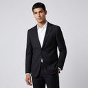 Oscar Pure Wool Jacket Black | Place the product on to a male model standing in a studio on a light grey background.