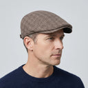 Tattersall Check Flat Cap Brown | Place this hat on the head of a male. The image should be taken in a studio setting on a light grey backround.