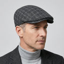 Tattersall Check Flat Cap Charcoal | Place this hat on the head of a male. The image should be taken in a studio setting on a light grey backround.