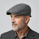 Tattersall Check Flat Cap Silver | Place this hat on the head of a male. The image should be taken in a studio setting on a light grey backround.